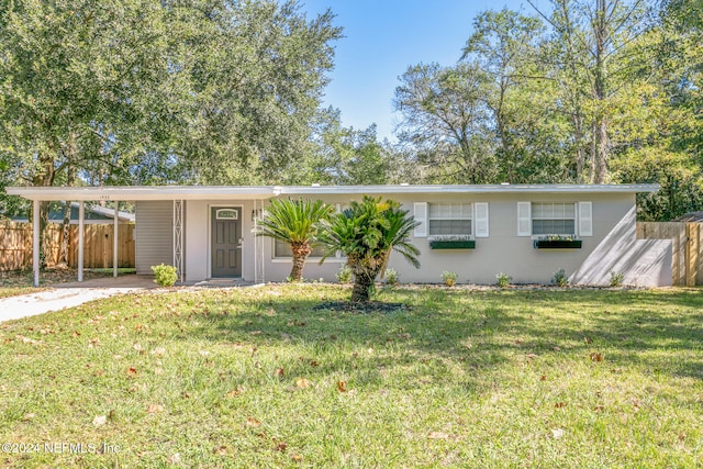 ranch-style house featuring a front yard and a carport