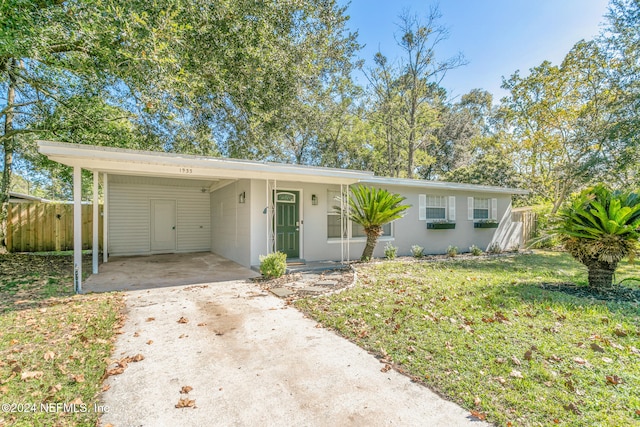 ranch-style home with a carport and a front lawn