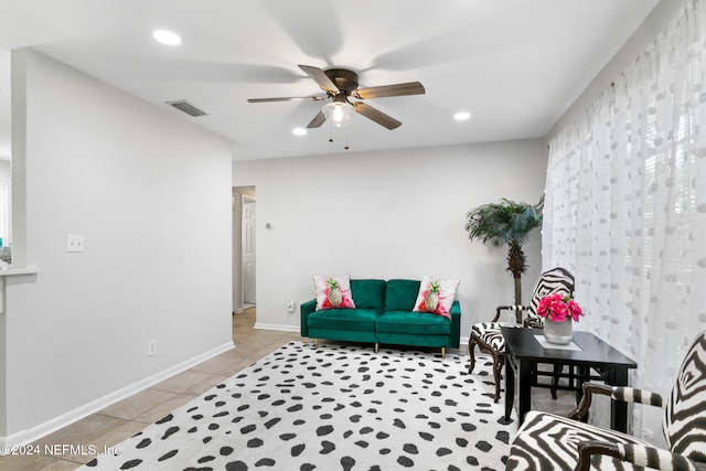 living area featuring light tile patterned floors and ceiling fan