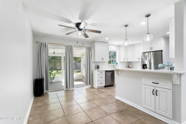 kitchen featuring decorative backsplash, white cabinets, light tile patterned floors, ceiling fan, and stainless steel appliances