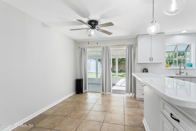 kitchen with white cabinets, hanging light fixtures, and backsplash