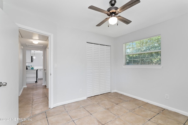 unfurnished bedroom with a closet, light tile patterned flooring, and ceiling fan