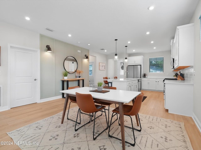 dining room featuring sink and light hardwood / wood-style flooring