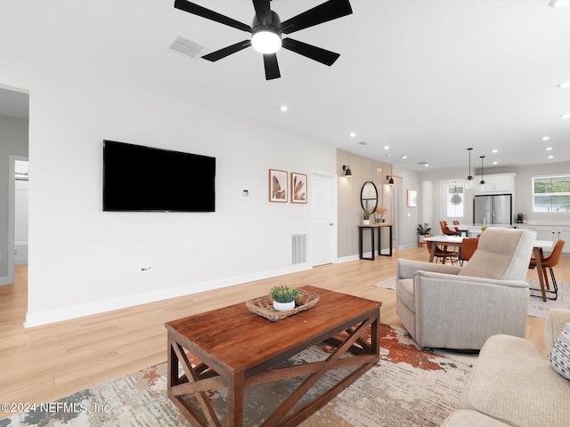 living room featuring light hardwood / wood-style floors and ceiling fan