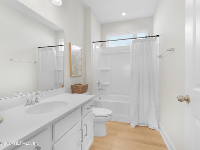 full bathroom featuring vanity, shower / tub combo, hardwood / wood-style flooring, and toilet