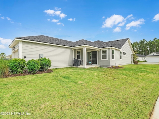 back of property with a yard, a patio area, and a garage