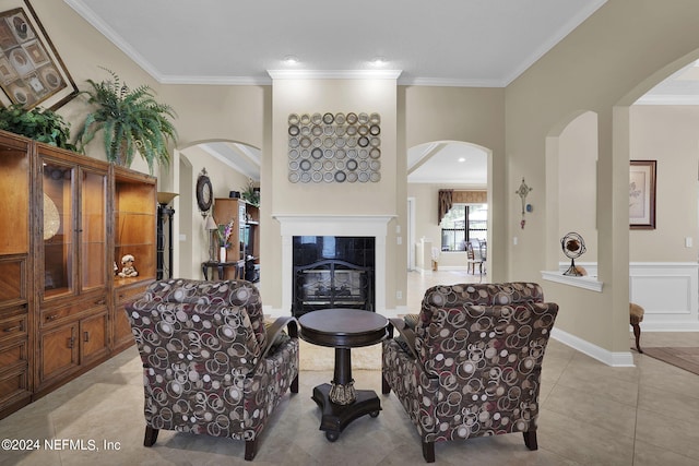 living room with a tiled fireplace, light tile patterned floors, and crown molding