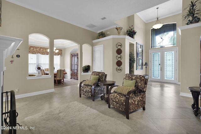 sitting room with ornamental molding, light tile patterned floors, french doors, and plenty of natural light