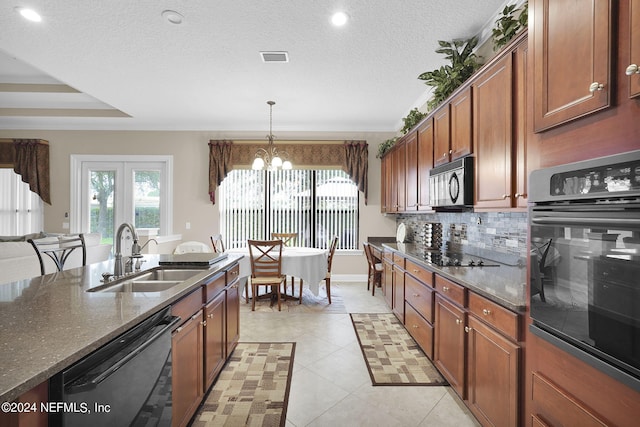 kitchen featuring sink, decorative light fixtures, black appliances, dark stone countertops, and an inviting chandelier