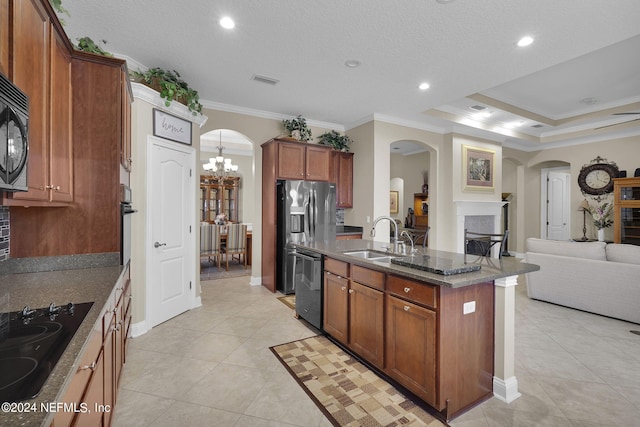 kitchen with a chandelier, sink, black appliances, a center island with sink, and ornamental molding