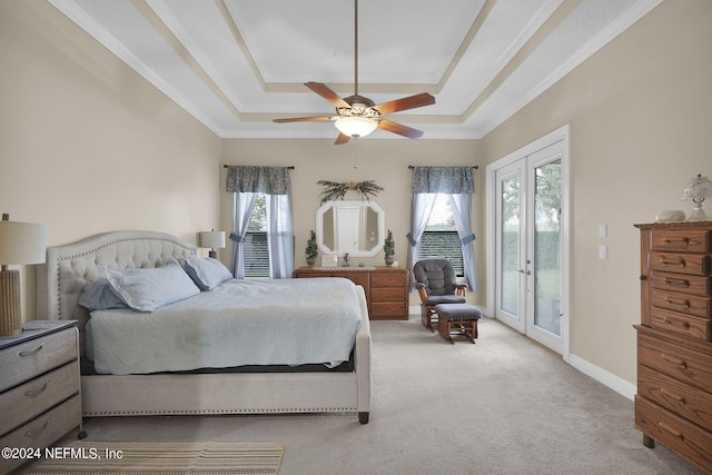 carpeted bedroom featuring a tray ceiling, access to outside, crown molding, ceiling fan, and french doors