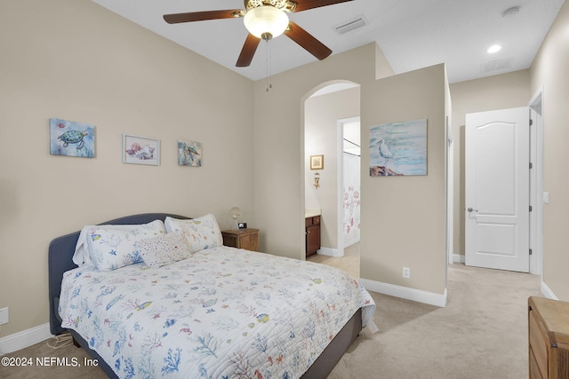 bedroom featuring ceiling fan, connected bathroom, and light carpet