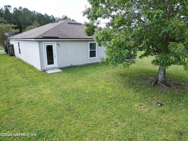 back of property with a lawn