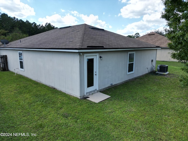 back of house featuring a yard and central air condition unit