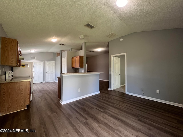 kitchen featuring white fridge, a textured ceiling, kitchen peninsula, lofted ceiling, and dark wood-type flooring