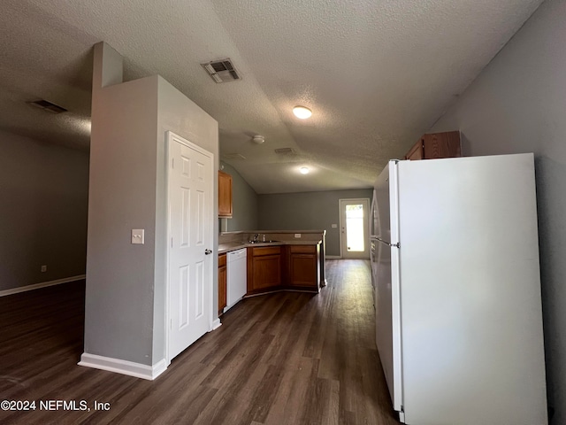 kitchen featuring white appliances, sink, a textured ceiling, vaulted ceiling, and dark hardwood / wood-style floors