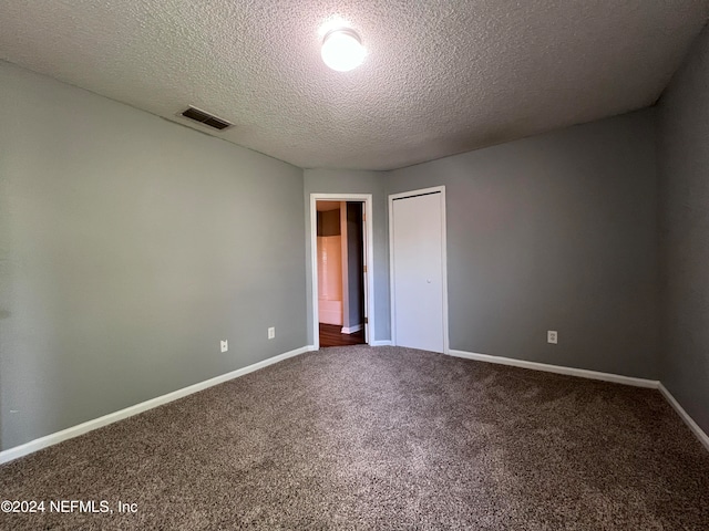 carpeted spare room featuring a textured ceiling