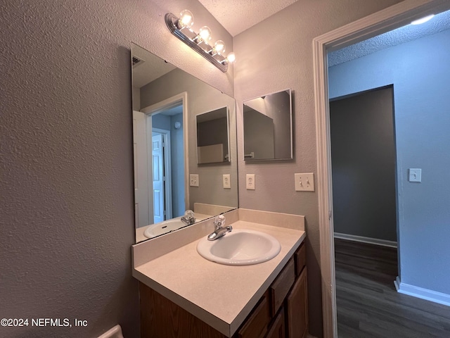 bathroom featuring vanity, hardwood / wood-style flooring, and a textured ceiling