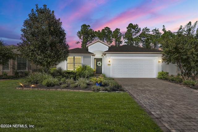 view of front of property with a garage and a lawn