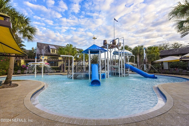 view of pool with a playground, a water slide, and pool water feature