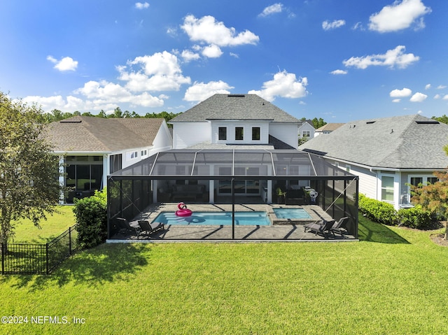 rear view of property with a lawn, a lanai, a patio, and a fenced in pool