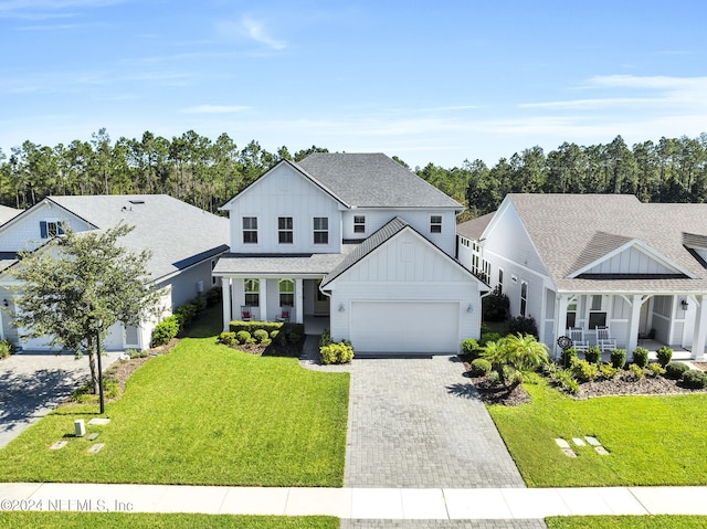 view of front of house with covered porch, a front yard, and a garage