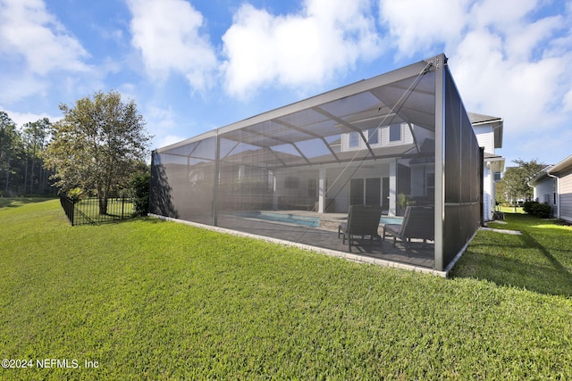 back of property featuring a patio, glass enclosure, and a yard