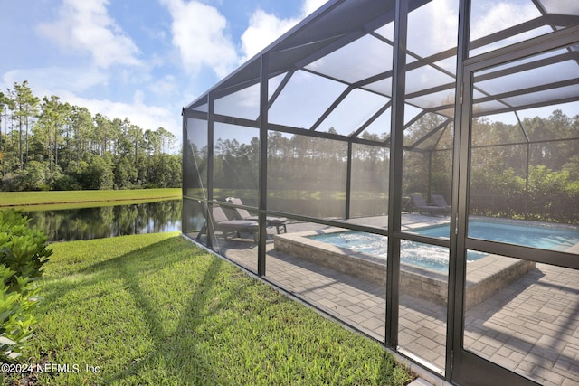 exterior space featuring a lanai, a patio, a water view, and a pool with hot tub