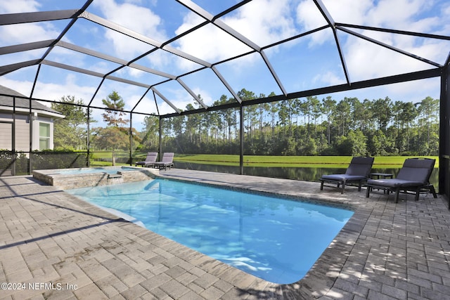 view of pool with an in ground hot tub, glass enclosure, a water view, and a patio area