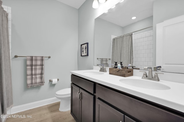 bathroom with curtained shower, hardwood / wood-style flooring, vanity, and toilet