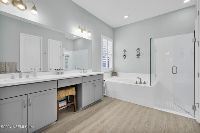 bathroom with hardwood / wood-style floors, vanity, and separate shower and tub