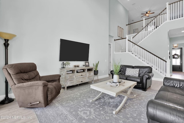 living room featuring a high ceiling, ceiling fan, and hardwood / wood-style flooring