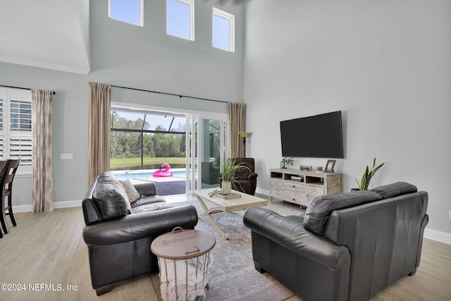 living room featuring a high ceiling and light hardwood / wood-style floors