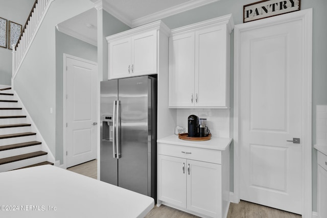 kitchen with white cabinets, backsplash, light hardwood / wood-style floors, and stainless steel fridge with ice dispenser