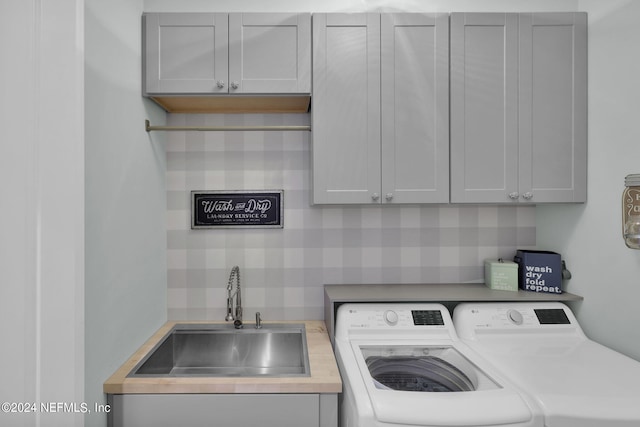 laundry room featuring cabinets, washer and dryer, and sink