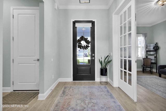 foyer with crown molding and light hardwood / wood-style floors