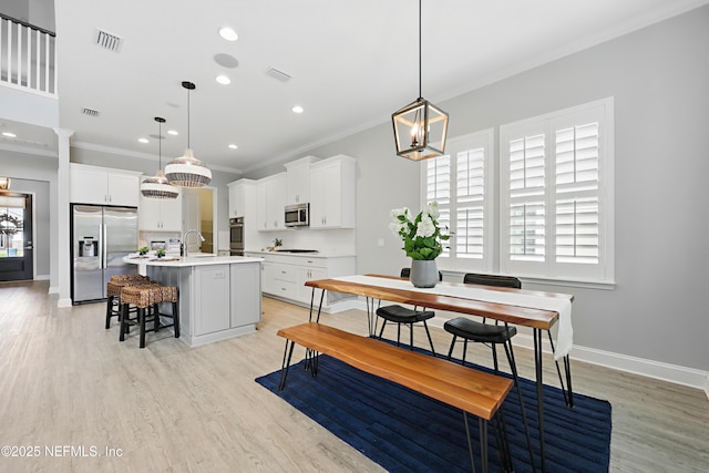 79 Shadow Ridge Trl, Ponte Vedra, FL 32081 - dining area with crown molding, light wood finished floors, baseboards, a notable chandelier, and visible vents