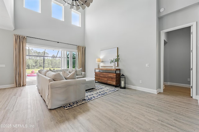 79 Shadow Ridge Trl, Ponte Vedra, FL 32081 - living room with wood finished floors, a high ceiling, baseboards, and an inviting chandelier