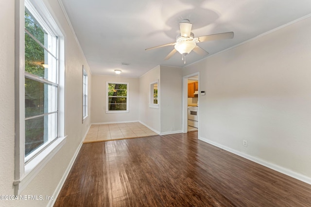 spare room with light wood-type flooring, crown molding, and ceiling fan