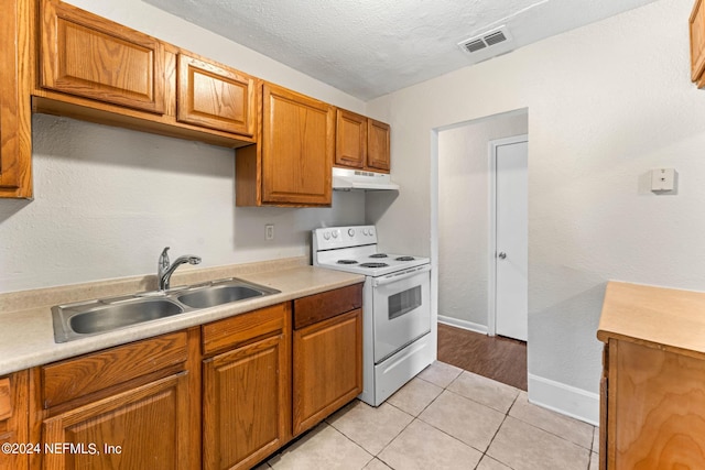 kitchen featuring sink, white electric stove, a textured ceiling, and light tile patterned flooring