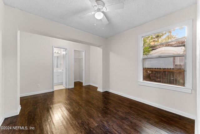 unfurnished room with a textured ceiling, dark hardwood / wood-style floors, and ceiling fan