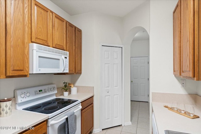 kitchen with white appliances and light tile patterned flooring