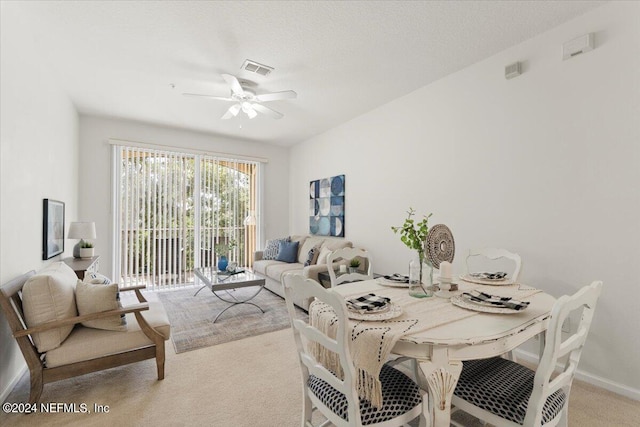 dining room featuring ceiling fan and light colored carpet