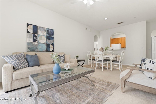 carpeted living room with ceiling fan