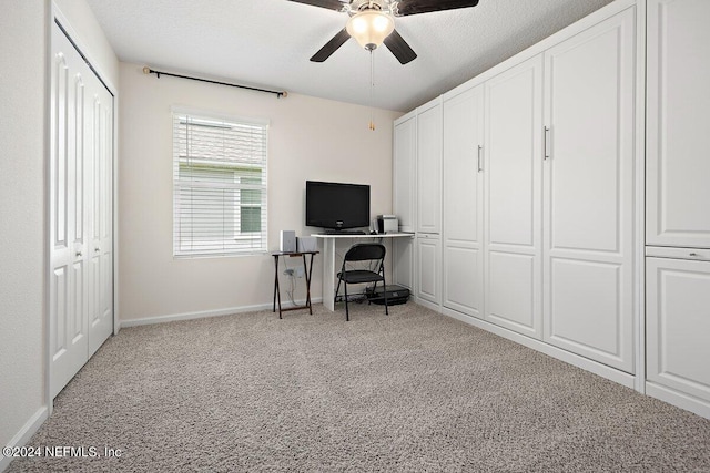 carpeted office with ceiling fan and a textured ceiling