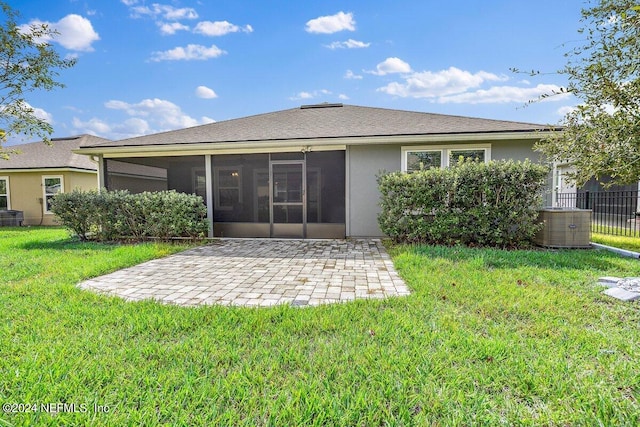 rear view of property with a lawn, a patio, a sunroom, and central air condition unit