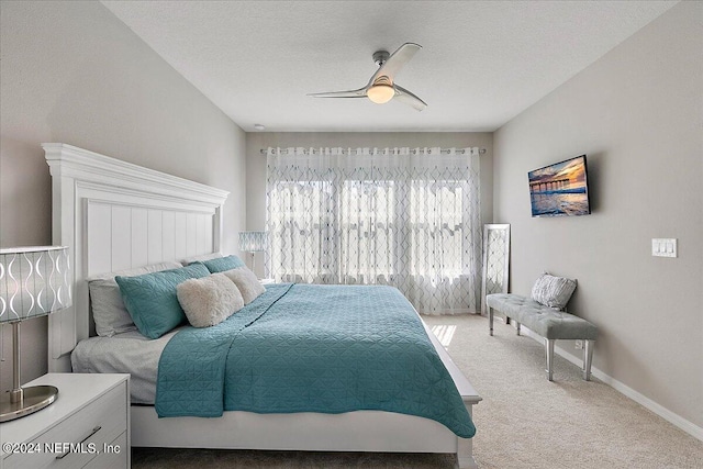 bedroom with a textured ceiling, carpet, and ceiling fan