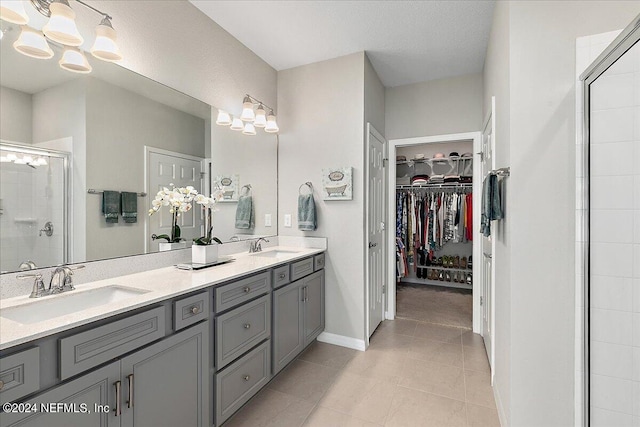 bathroom featuring tile patterned flooring, vanity, and a shower with shower door