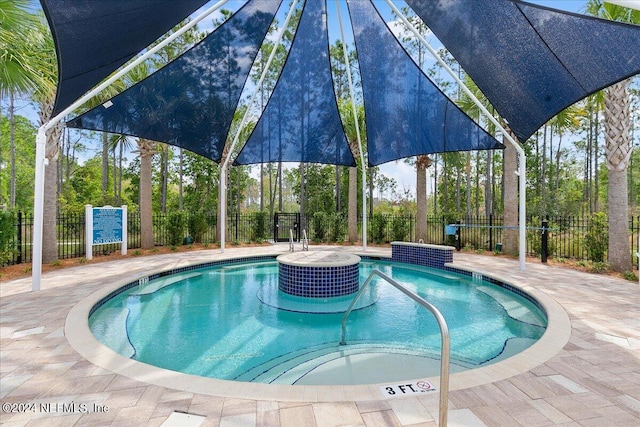 view of swimming pool featuring a jacuzzi and a patio