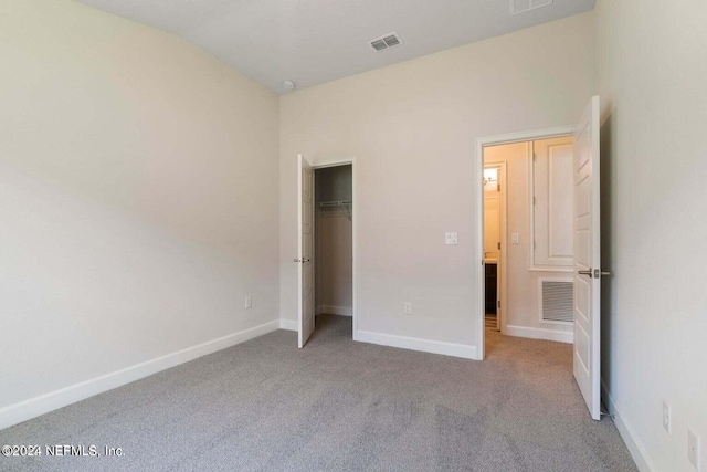 unfurnished bedroom featuring light colored carpet, visible vents, and baseboards